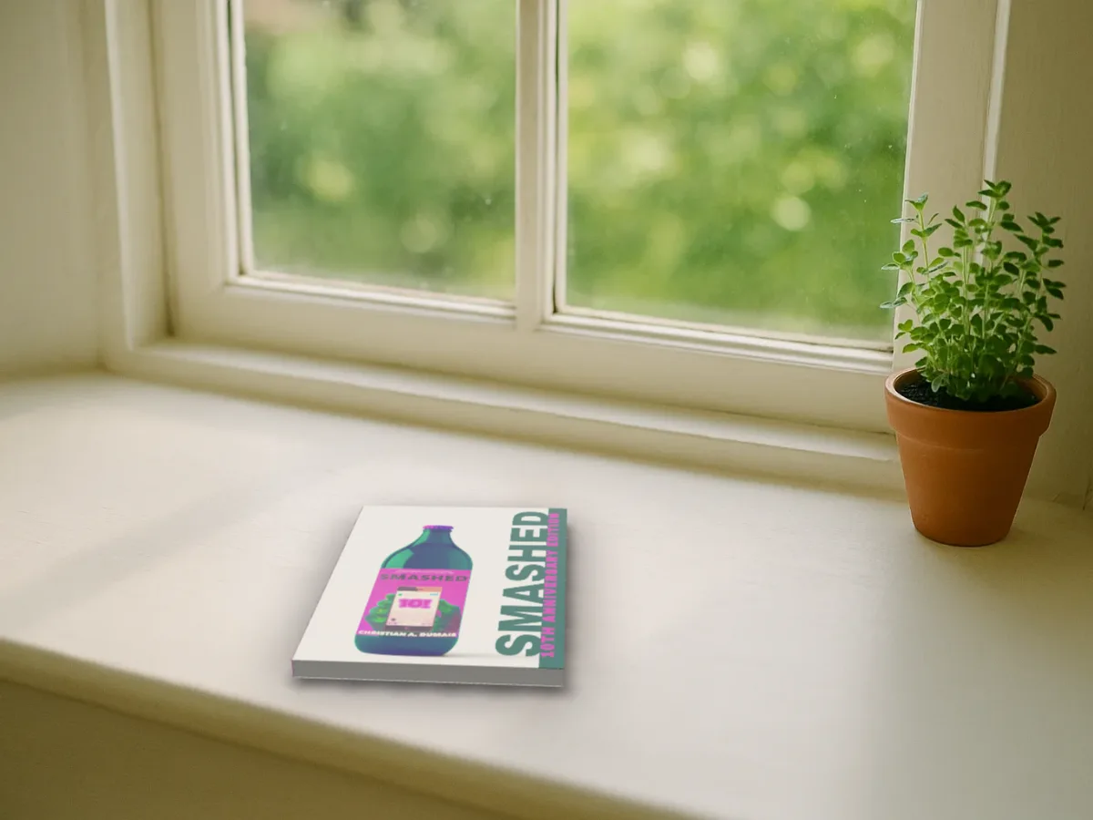 Smashed by Christian A. Dumais lying on a sunny white windowsill beside a pot plant