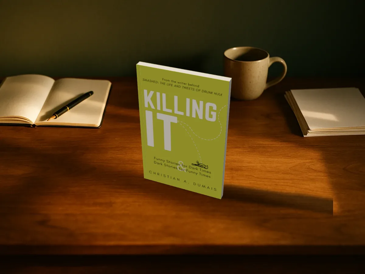 Killing It standing on a writer's desk beside an open notebook and a mug